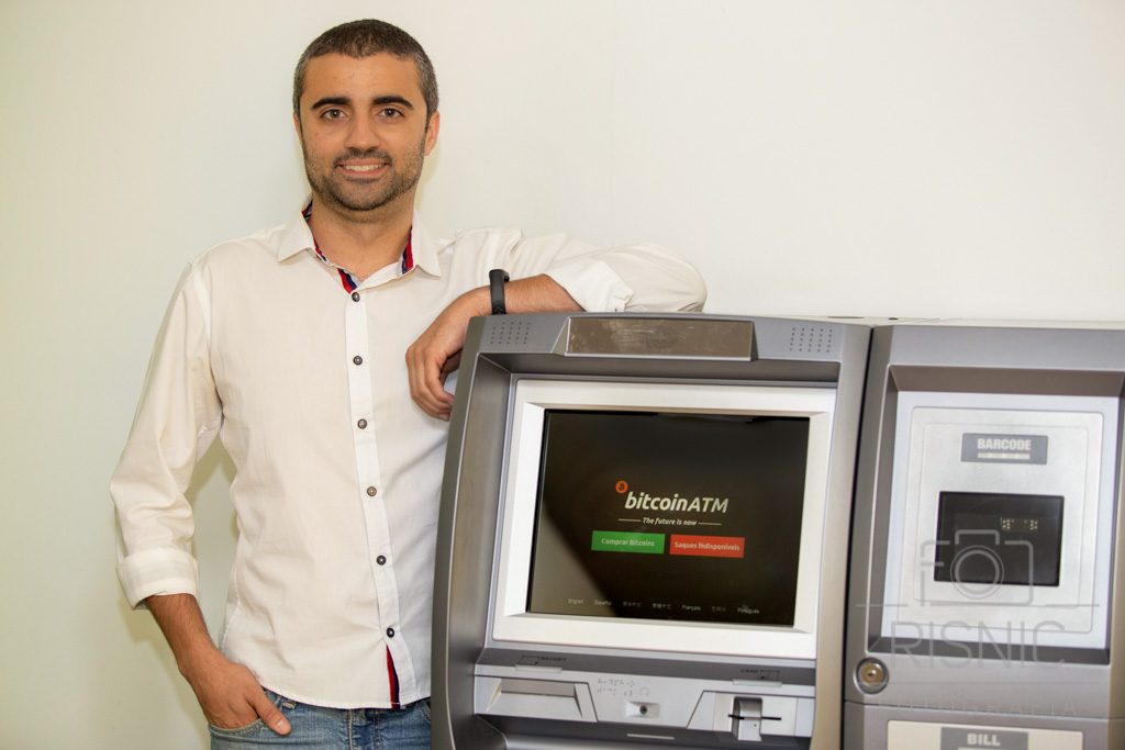 Retrato Corporativo de Arthur Souza, ao lado de caixa automático de criptomoedas