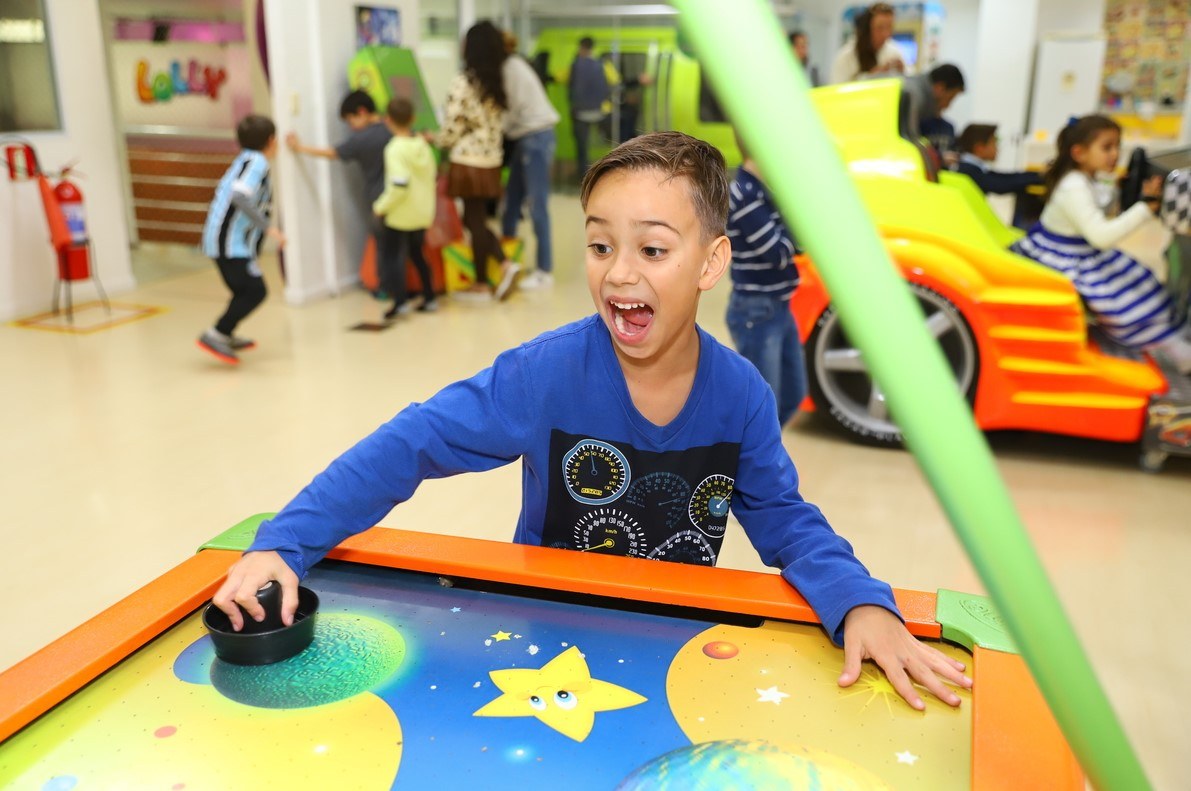 Criança brincando em brinquedo durante festa infantil em São Paulo.