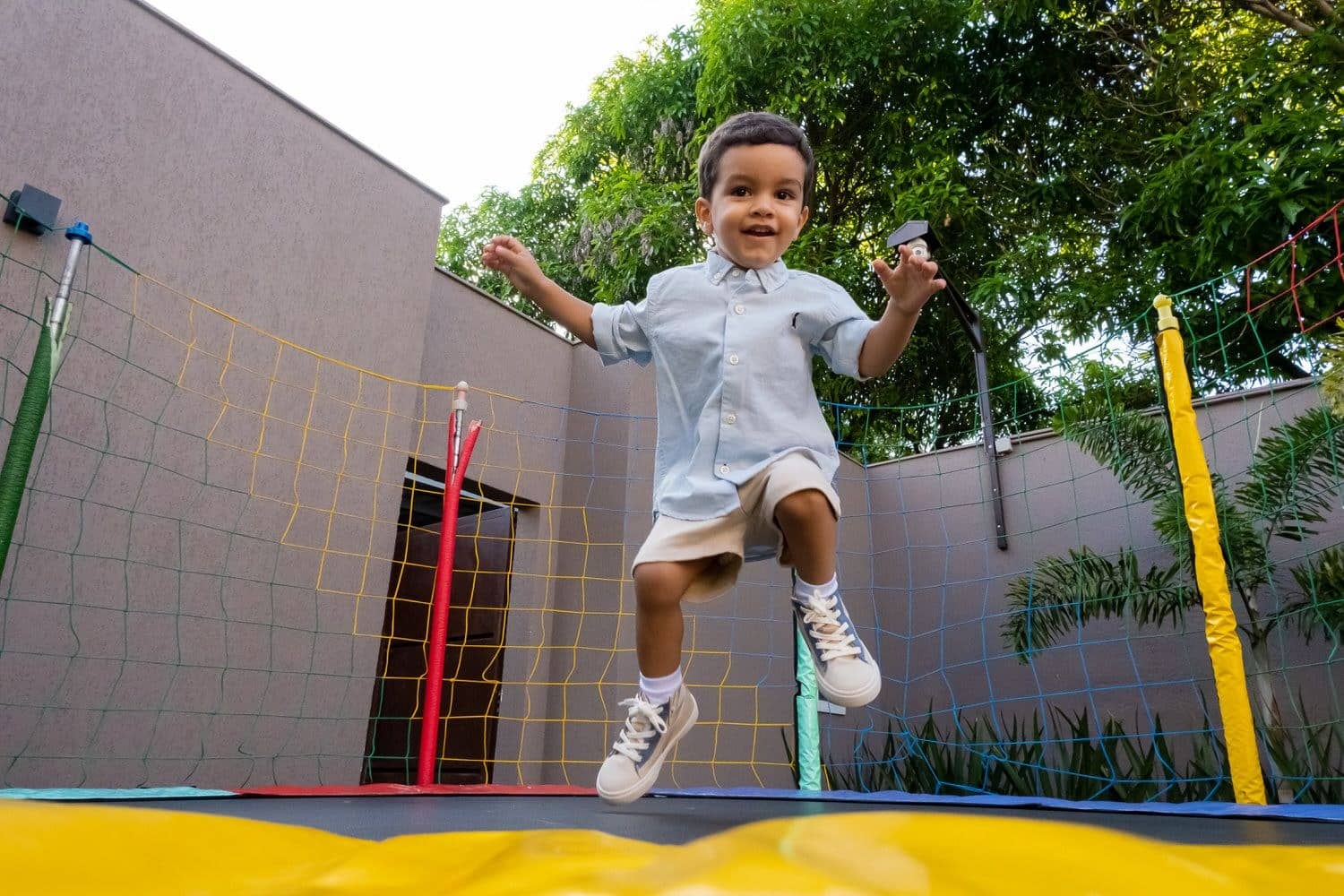 Criança pulando em trampolim durante festa infantil em São Paulo.