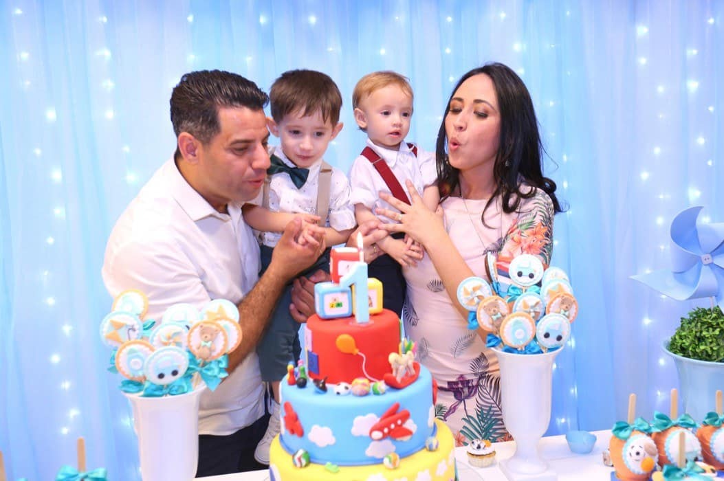 Família reunida durante o parabéns em festa infantil.
