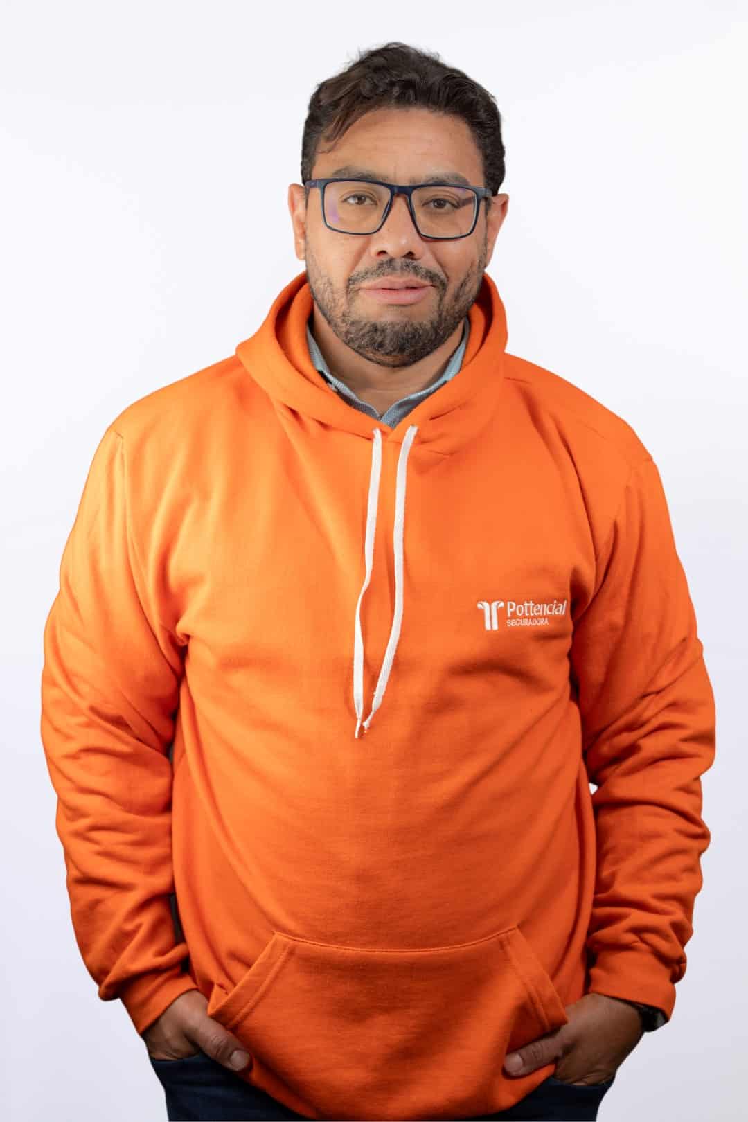 Retrato profissional de colaborador da Pottencial Seguradora com moletom laranja