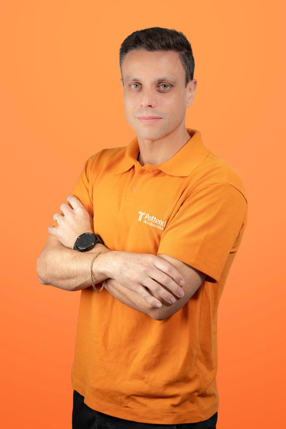 Retrato corporativo de colaborador da Pottencial Seguradora usando óculos e moletom laranja